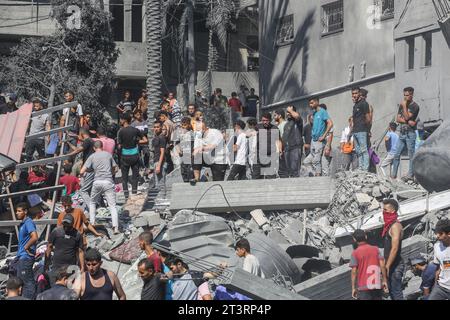 Gaza, Palestina. 26 ottobre 2023. I palestinesi cercano i sopravvissuti e i corpi delle vittime attraverso le macerie di edifici distrutti durante i bombardamenti israeliani, a Khan Yunis, nella Striscia di Gaza meridionale. Migliaia di civili, sia palestinesi che israeliani, sono morti dal 7 ottobre 2023, dopo che i militanti palestinesi di Hamas con base nella Striscia di Gaza sono entrati nel sud di Israele in un attacco senza precedenti che ha innescato una guerra dichiarata da Israele ad Hamas con attentati di rappresaglia a Gaza. (Foto di Ahmed Zakot/SOPA Images/Sipa USA) credito: SIPA USA/Alamy Live News Foto Stock