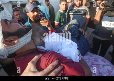 Un parente di Wael al-Dahdouh piange i bambini e altri membri della famiglia al-Dahdouh, tutti uccisi il giorno prima in uno sciopero israeliano sul campo di Nuseirat, per la sepoltura presso l'ospedale al-Aqsa di Deir al-Balah, nella Striscia di Gaza meridionale, il 26 ottobre 2023. La famiglia del giornalista di al Jazeera è stata uccisa in uno sciopero israeliano a Gaza, la rete con sede in Qatar ha dichiarato in una dichiarazione del 25 ottobre, mentre la guerra infuria tra Israele e Hamas. Al Jazeera ha detto che la moglie e i due figli del corrispondente di Gaza del suo canale in lingua araba Wael al-Dahdouh sono stati uccisi in uno sciopero sul rifugio di Nuseirat Foto Stock