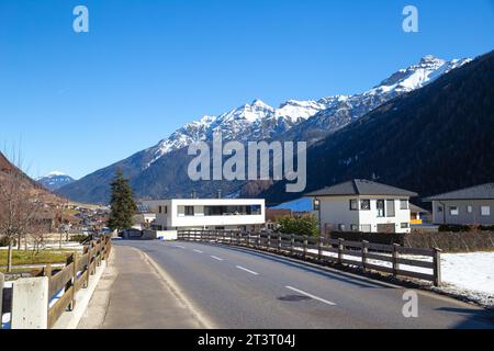 Villaggio alpino con montagna innevata sullo sfondo Foto Stock