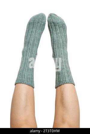 Gambe femminili in calzini di lana lavorati a mano blu isolate su sfondo bianco, percorso di ritaglio incluso Foto Stock