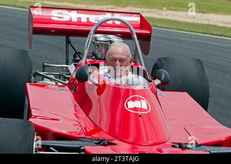 La leggenda neozelandese del Motorsport, Chris Amon, si riprende con la vettura da corsa Talon MR1A di Formula 5000 1974 che guidò nella Tasman Cup 1975 Foto Stock