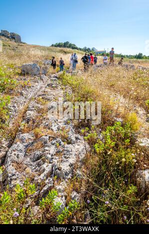 I turisti aspettano durante un tour guidato all'aperto dei resti di un'antica città Foto Stock