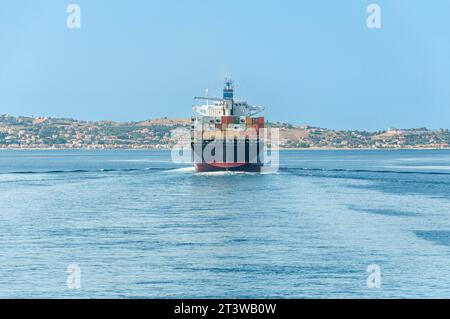 Vista poppa di una nave portacontainer che attraversa lo stretto di Messina Foto Stock