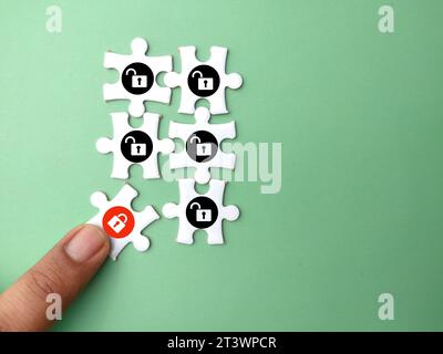 Un puzzle bianco con un'icona a forma di lucchetto aperta e una bloccata. lucchetto per la sicurezza informatica. il concetto di sicurezza Foto Stock