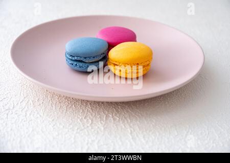 macaron di colori diversi e vari cioccolatini su sfondo bianco in primo piano Foto Stock