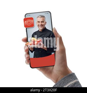 Chef sorridente sullo schermo dello smartphone: Assumi professionisti online e cucina su richiesta Foto Stock