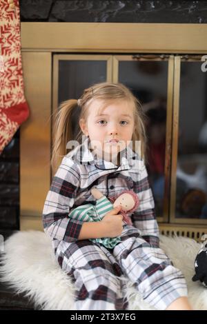 Contenuto: Il bambino tiene la bambola fatta a mano, sorridendo dolcemente Foto Stock