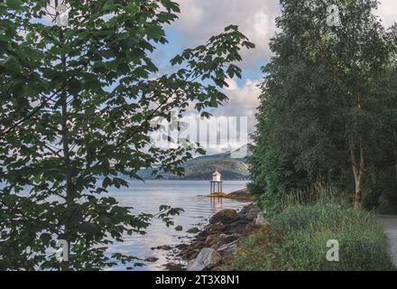 Faro sulla riva di un fiordo in Norvegia Foto Stock