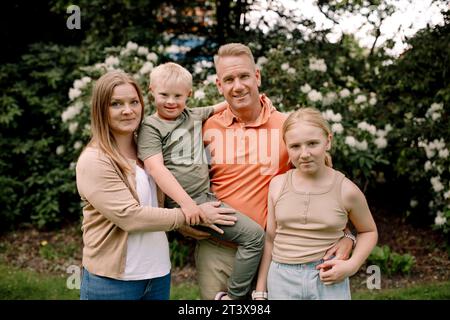 Ritratto di famiglia sorridente in piedi in posizione di parcheggio Foto Stock