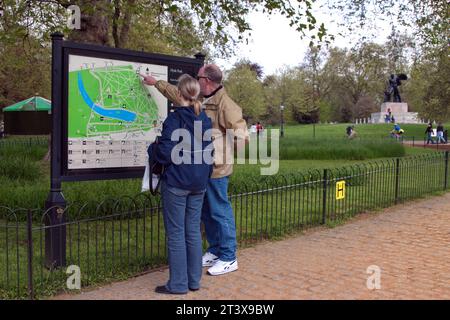 Turisti di fronte a una mappa di Hyde Park, Londra, Regno Unito. Foto Stock