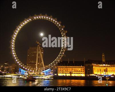 London Eye e County Hall di notte con una luna piena . Londra Regno Unito. Foto Stock