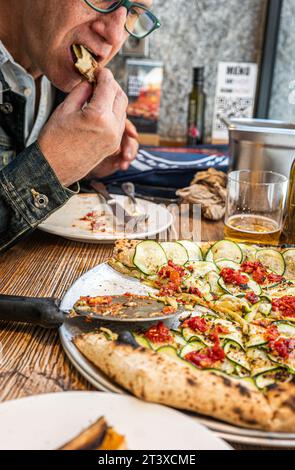 Pizza di zucchine napoletane su un rustico tavolo in legno in una pizzeria tradizionale. Foto Stock