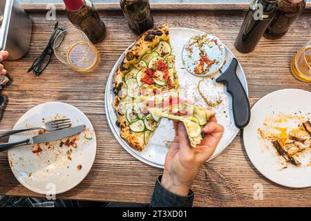 Pizza di zucchine napoletane su un rustico tavolo di legno in una pizzeria tradizionale. Foto Stock
