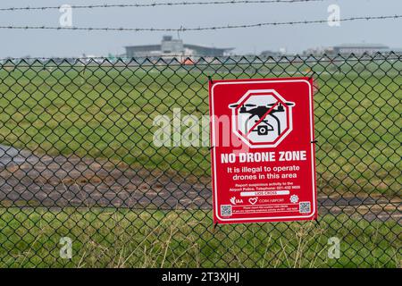 Cartello di avvertimento "No Drone zone" sulla recinzione perimetrale dell'aeroporto di Cork, Cork, Irlanda. Foto Stock