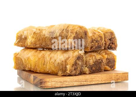 Diversi pezzi di dolce baklava su un tavolo da cucina in legno, macro, isolato su sfondo bianco. Foto Stock