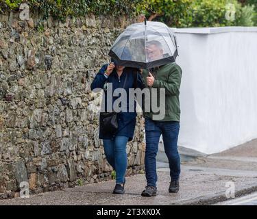 Persone che lottano contro i venti forti e la pioggia forte sotto un Met Éireann Weather Warning a Tramore, Co. Waterford, Irlanda. Foto Stock