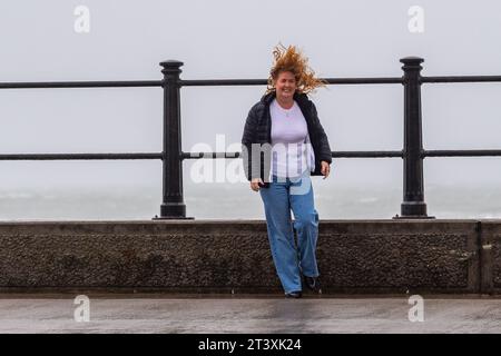 Persone che lottano contro i venti forti e la pioggia forte sotto un Met Éireann Weather Warning a Tramore, Co. Waterford, Irlanda. Foto Stock