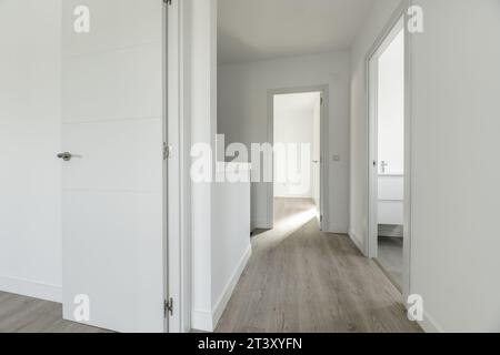 Corridoio distributore di una casa residenziale a due piani con falegnameria in legno bianco sulle porte Foto Stock