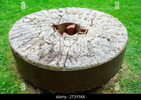 Toronto, Canada, un'antica mola in pietra e metallo posta a terra. Il vecchio oggetto apparteneva a un ex mulino dell'epoca coloniale. (Foto Foto Stock
