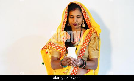 Giovane donna indiana che indossa costume tradizionale e tiene karwa o karva al festival di karva chauth. Foto Stock