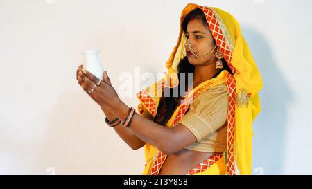 Donna con caramelle karwa, felice karva chauth festival. Giovane donna indiana che tiene dolci un'occasione di festa femminile. Foto Stock