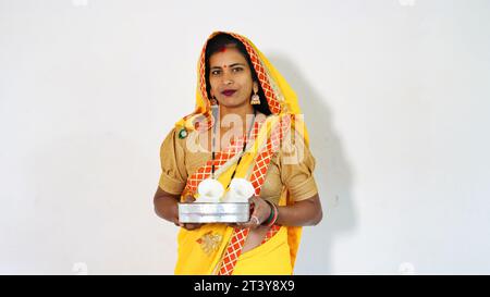 Donna che posa felicemente mentre tiene un festival Puja thali. Donna che guarda verso la telecamera con un sorriso sul volto - Diwali Karwa Chauth Festival Foto Stock