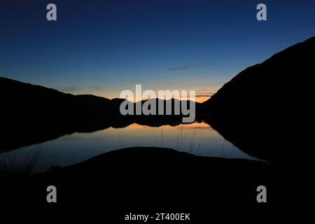 Splendido riflesso al crepuscolo dell'ora blu sull'incontro delle acque nel Parco Nazionale di Killarney in inverno. Vista dal punto di osservazione sul Ring of Kerry Foto Stock