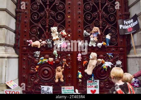 Londra, Regno Unito. 27 ottobre 2023. I giocattoli sono visibili all'ingresso del Ministero degli Esteri durante la dimostrazione. Genitori e bambini si riunirono al di fuori del Foreign, Commonwealth and Development Office a Westminster chiedendo un immediato cessate il fuoco a Gaza e collocarono orsacchiotti e altri giocattoli, in rappresentanza dei bambini palestinesi uccisi durante la guerra Israele-Hamas, fuori dall'edificio del governo. Credito: SOPA Images Limited/Alamy Live News Foto Stock