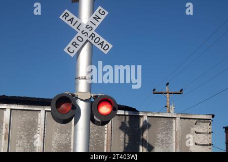 Cartello per attraversare la ferrovia davanti al treno Foto Stock