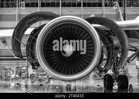 Ripresa ravvicinata della turbina smontata di un aereo nell'hangar. Disassemblaggio e riparazione in corso.Vista frontale. Bianco e nero. Foto Stock