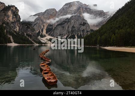 Barche di legno sul Lago di Braies (Pragser Wildsee) nelle Dolomiti di Braies in alto Adige, Italia. Splendida vista sulle montagne sullo sfondo. Foto Stock