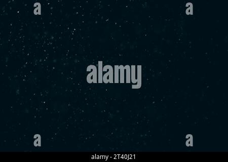 Primo piano della neve bianca che cade su sfondo nero del cielo notturno invernale al buio Foto Stock