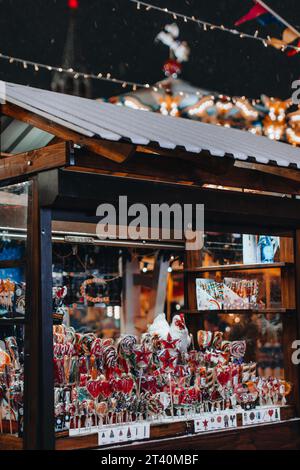 Mercatino di Natale. Inverno. Chiosco di legno alla fiera delle vacanze con dolci e lecca lecca la sera. Foto Stock