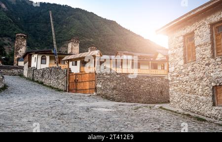 Ampia antica steet di Mestia vicino a torri di cigno con mura di pietra e casa, Georgia Foto Stock