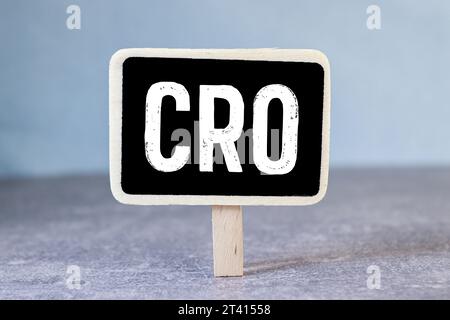 Testo CRO su white paper su sfondo chiaro con carta per grafici Foto Stock