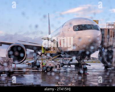 Toronto, Ontario, Canada - 07 24 2022 : Boeing 777 aereo di linea di Air Canada parcheggiato nell'aeroporto di Toronto visto attraverso il vetro con gocce di pioggia Foto Stock