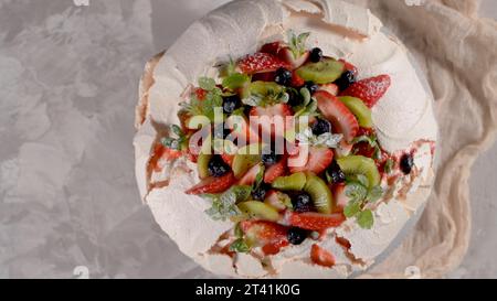 Torta Pavlova con mirtilli freschi, fragole e kiwi. Foto Stock