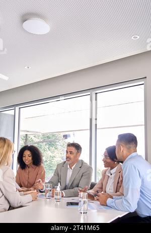 Un team aziendale internazionale felice e impegnato che parla durante una riunione aziendale in ufficio. Foto Stock