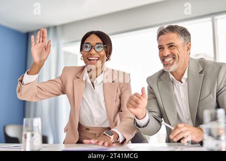 I leader internazionali dei team esecutivi festeggiano il successo al tavolo delle riunioni. Foto Stock