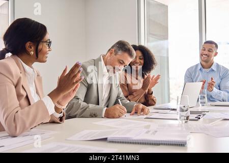Buon vecchio uomo d'affari che firma un documento d'affari legale alla riunione del Consiglio. Foto Stock