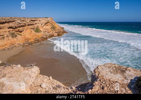 Vista aerea delle onde che si snodano in una piccola baia sotto le aspre scogliere di Venus Bay sulla penisola di Eyre, nel sud dell'Australia Foto Stock