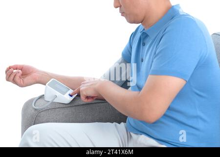 Uomo che si prende la pressione sanguigna Foto Stock