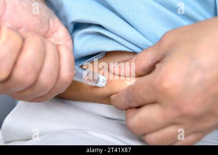 Uomo auto-iniettante Foto Stock