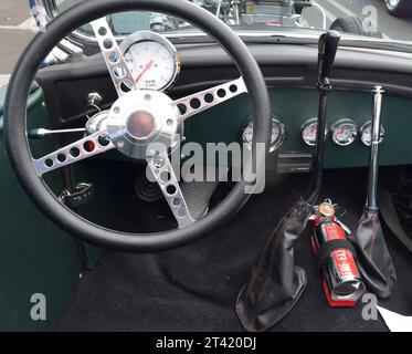 Immagine ravvicinata del cruscotto di un'auto con il volante e comandi e accessori dettagliati Foto Stock