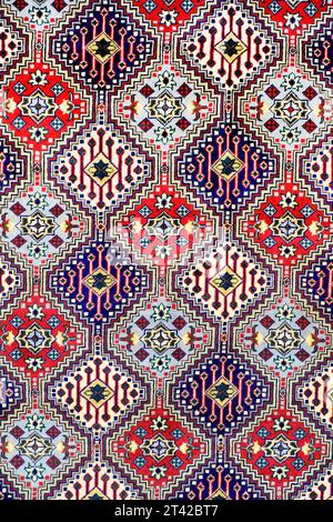 Il tappeto viene arrotolato ed esposto in una mostra di tappeti a pune, tappeto in seta con design floreale del Kashmir, pila di tappeti di qualità multicolore, Made in India Foto Stock