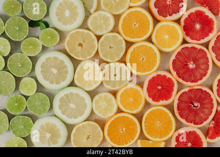 Una vivace esposizione di agrumi, composta da limoni e limoni in vari tipi su un tavolo di legno Foto Stock