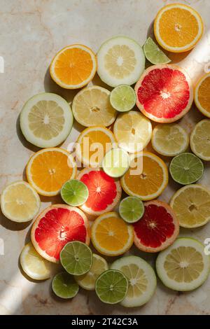Una vivace esposizione di agrumi, composta da limoni e limoni in vari tipi su un tavolo di legno Foto Stock