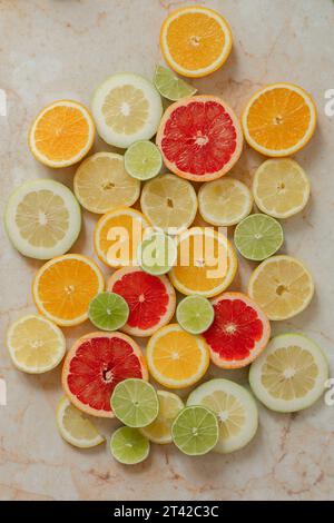 Una vivace esposizione di agrumi, composta da limoni e limoni in vari tipi su un tavolo di legno Foto Stock