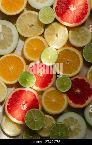 Una vivace esposizione di agrumi, composta da limoni e limoni in vari tipi su un tavolo di legno Foto Stock