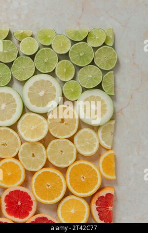 Una vivace esposizione di agrumi, composta da limoni e limoni in vari tipi su un tavolo di legno Foto Stock